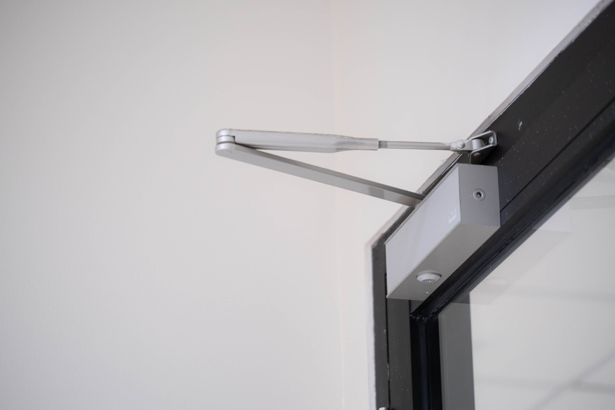 Ferme porte groom monté sur une porte vitrée